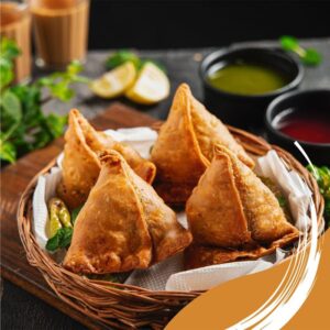 A tempting plate of crispy samosas with mint and tamarind chutney, perfect for a snack or appetizer.