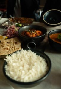 Delicious Indian meal featuring rice, curry, and naan in a London eatery.