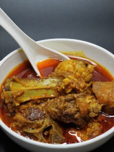 Delicious Indian mutton curry served in a white bowl, rich with spices.