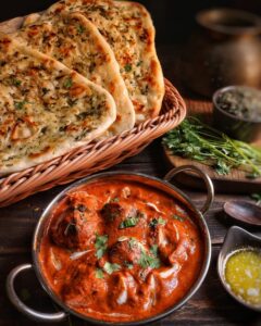 Close-up of flavorful butter chicken with garlic naan, capturing the essence of Rasoi House.