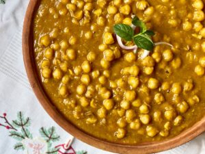 A close-up of traditional Indian chana masala garnished with fresh herbs, showcasing its rich and appetizing flavors.